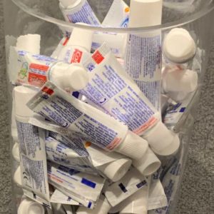 A bowl of small tubes of toothpaste