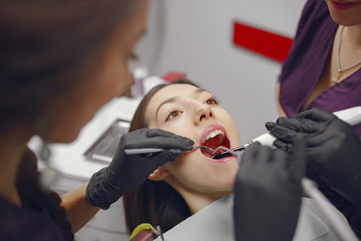 Dentist examining patient's teeth with tools