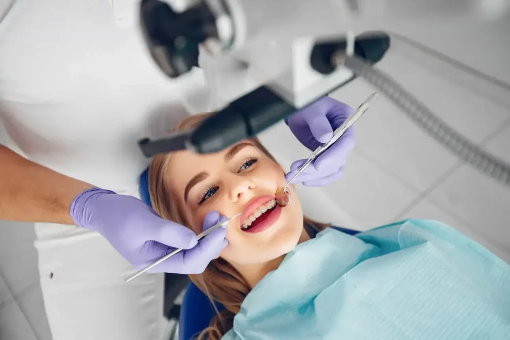 Dentist examining a smiling patient with braces.