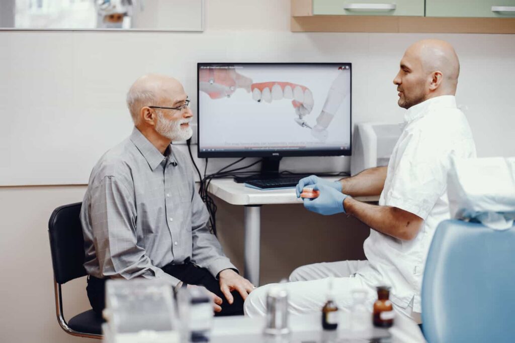 Dentist consulting an elderly patient about dentures