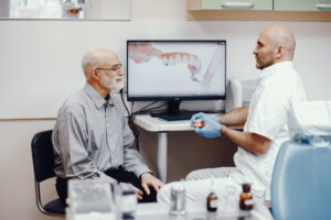 Doctor explaining denture implants to elderly man