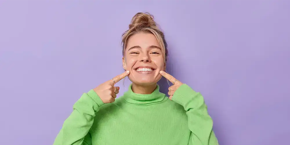Girl smiling pointing to her mouth